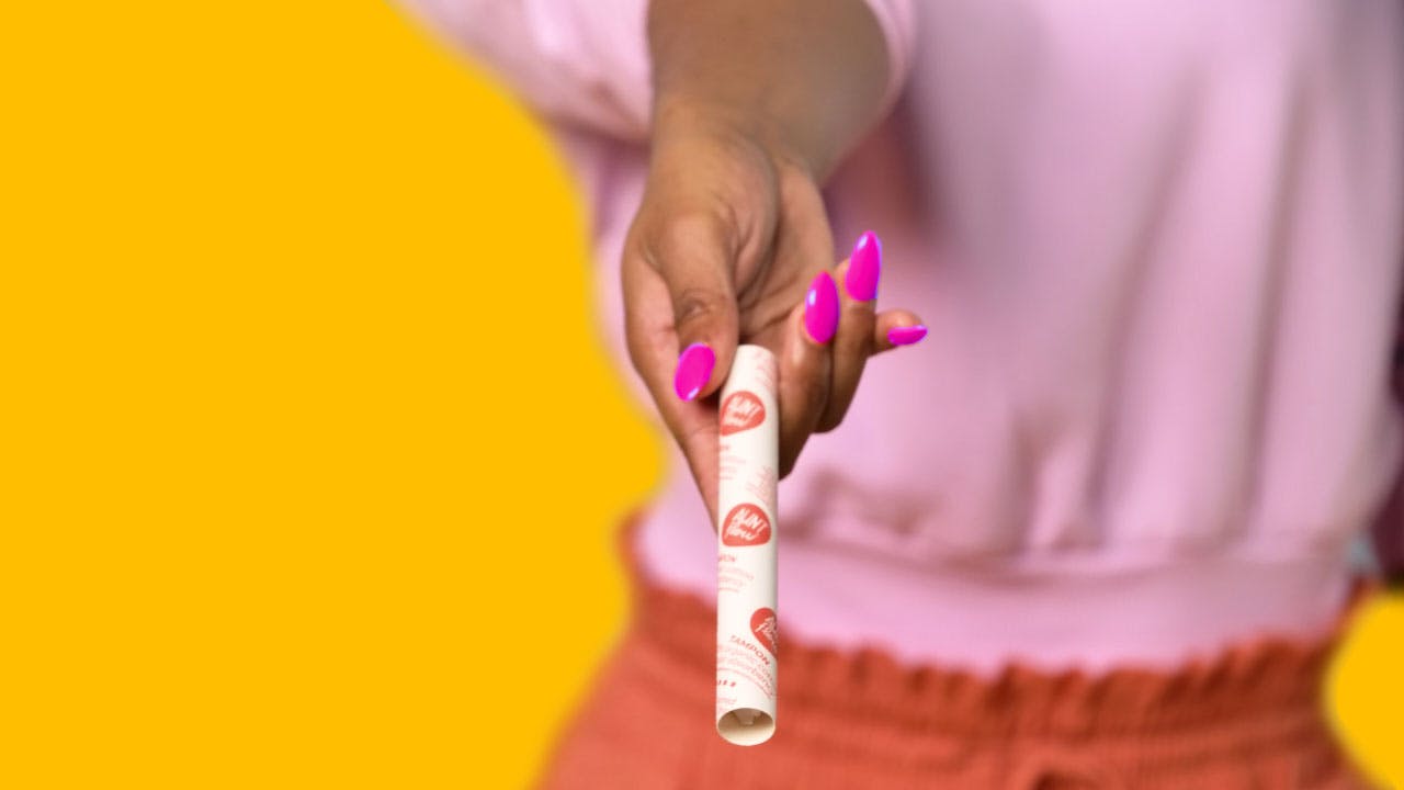 A hand ith nail polish presenting a tampon