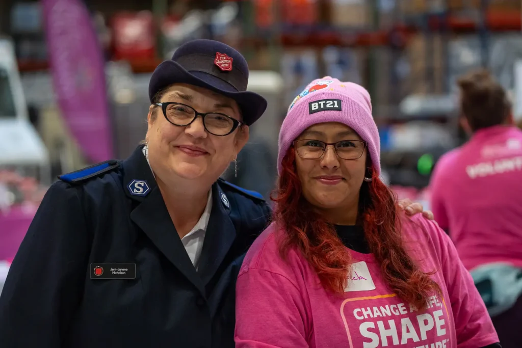 Two women at a Justice Necessary volunteer event smiling together.